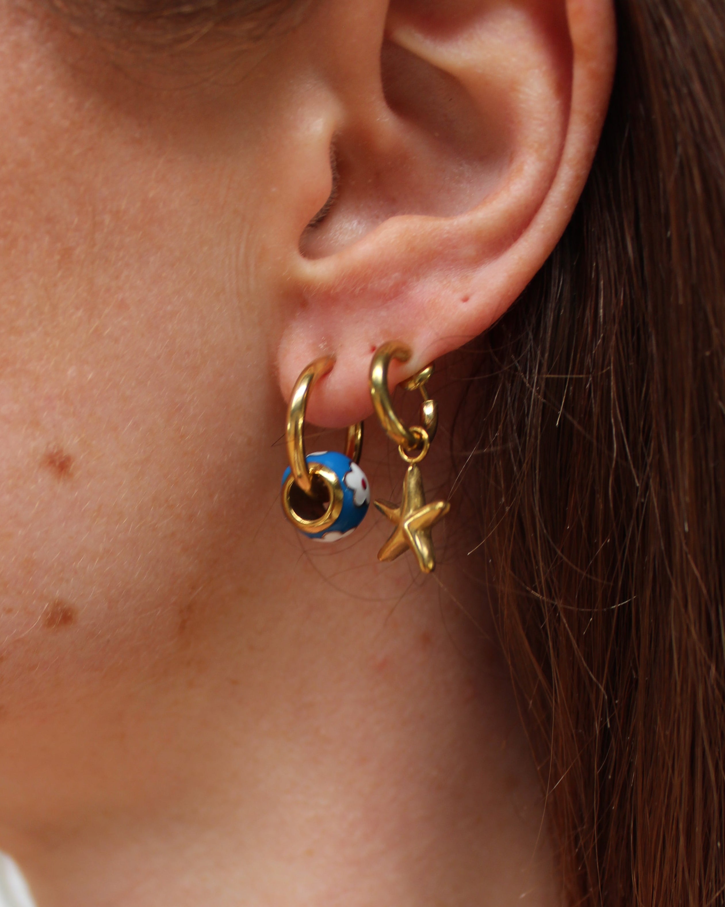 2 clip on oorbellen met bedels van een zeester en een bloementje